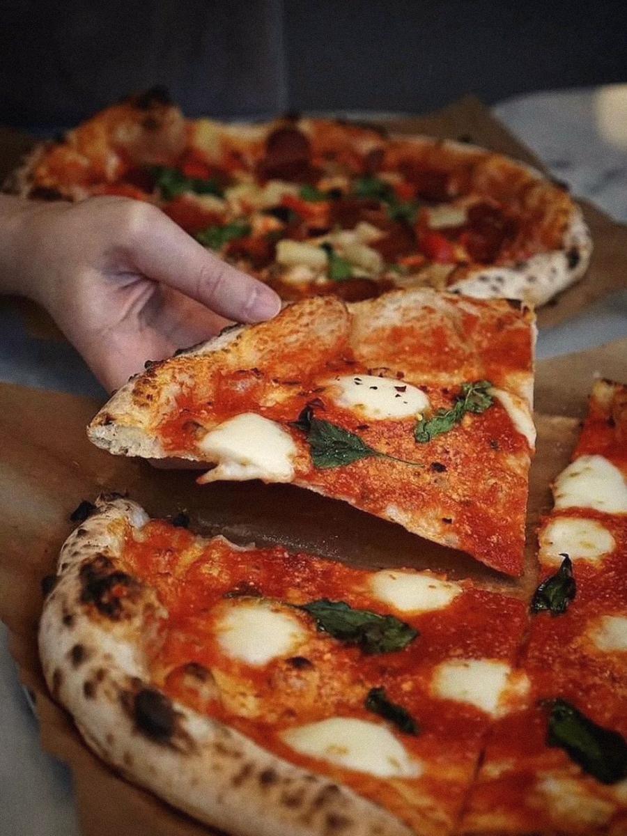A slice being pulled from a fresh Margherita