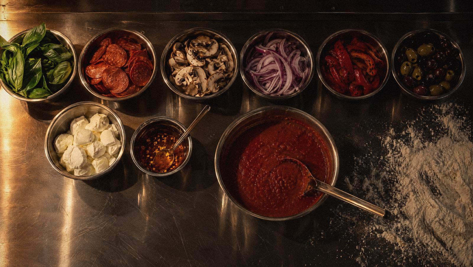 The topping bar: bowls of basil, pepperoni, mushrooms, peppers, olives and fior di latte